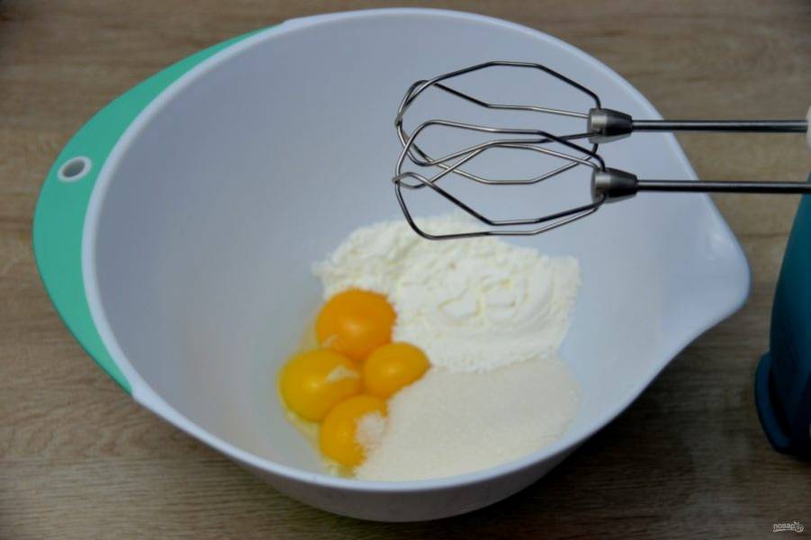 Начните с приготовления заварного ванильного крема. Для этого взбейте 4 яичных желтка с сахаром и крахмалом.