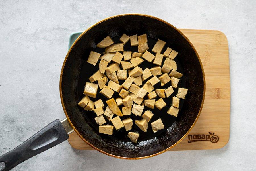 Нарежьте сейтан на кубики среднего размера. Обжарьте в сковороде 3-5 минут.