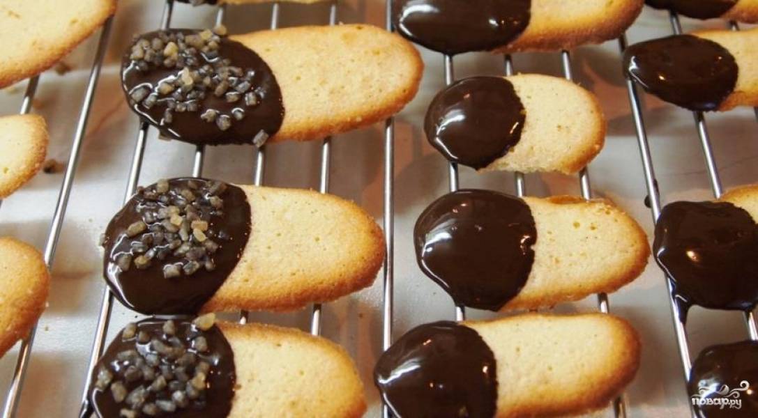 Растопите шоколад на водяной бане и окуните кончики печенья в него. Если хотите, можете еще в сахар обмакнуть. 
Дайте шоколаду застыть, поместив печенье на решетку. 