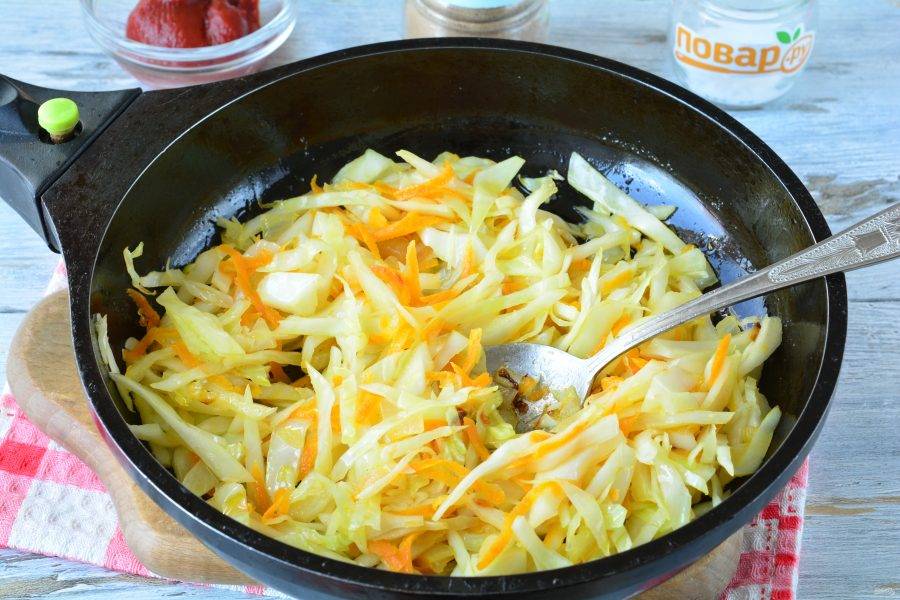Нашинкуйте капусту. Морковку натрите на терке, а лук мелко нарежьте. Овощи обжаривайте на сковороде с растительным маслом 3-4 минуты на среднем огне, помешивая. Посолите и поперчите по вкусу.