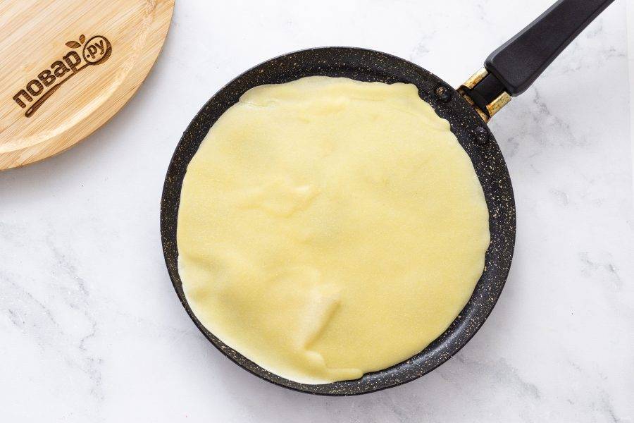 Разогрейте сковороду на среднем огне, смажьте растительным маслом. Аккуратно распределите тесто по всей поверхности сковороды. Жарьте блин на средне-низком огне пару минут, затем переверните и жарьте еще 1-1,5 минуты.
