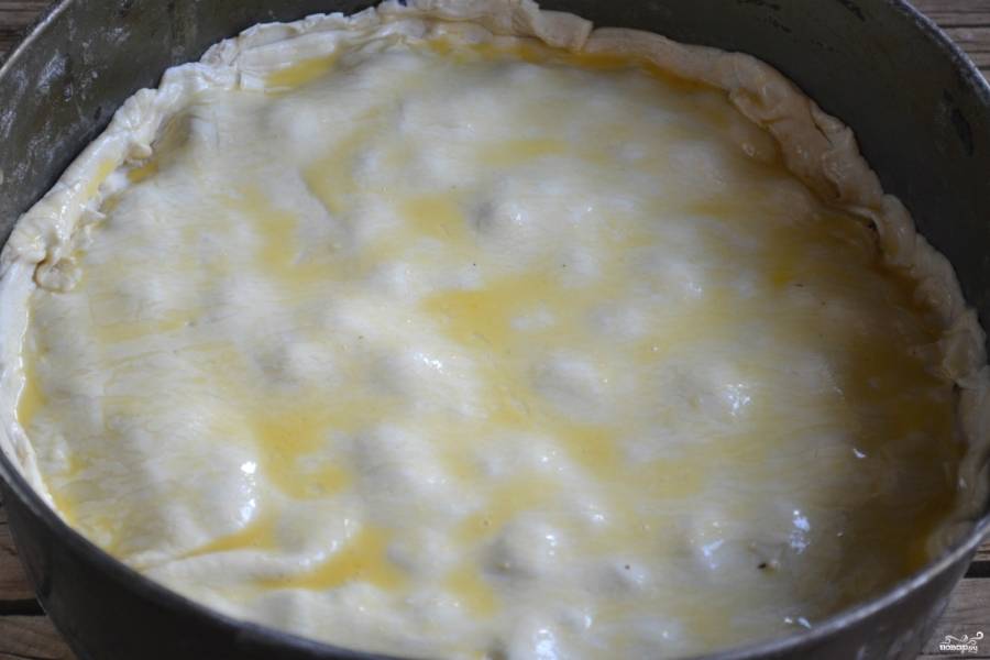 Смажьте поверхность пирога взбитым яйцом.