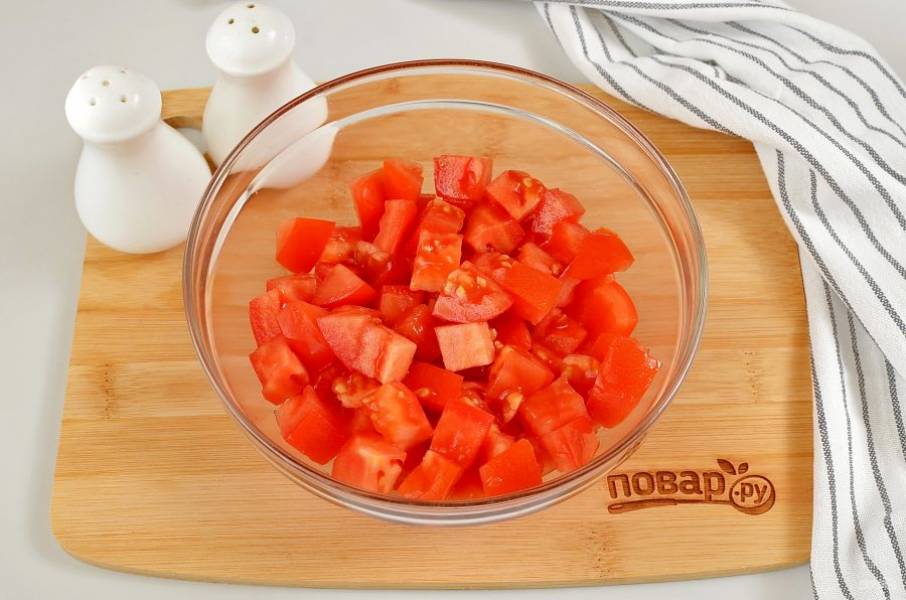 Порежьте помидоры крупными кубиками. Выложите в салатник.