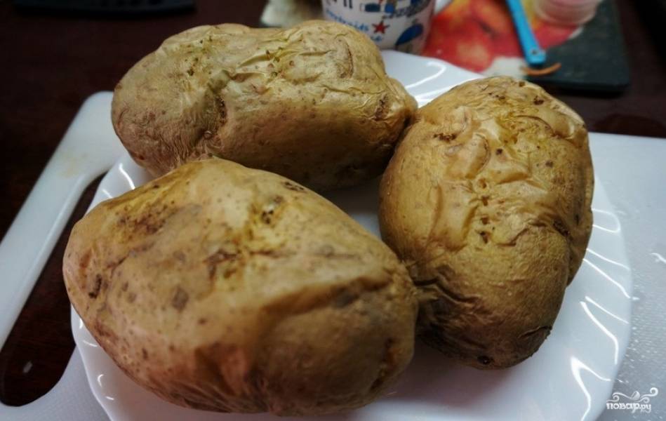 Картофель тщательно промойте, сделайте в нём проколы в нескольких местах вилкой. Поместите его в микроволновку (духовку), установите режим "картофель в мундире".