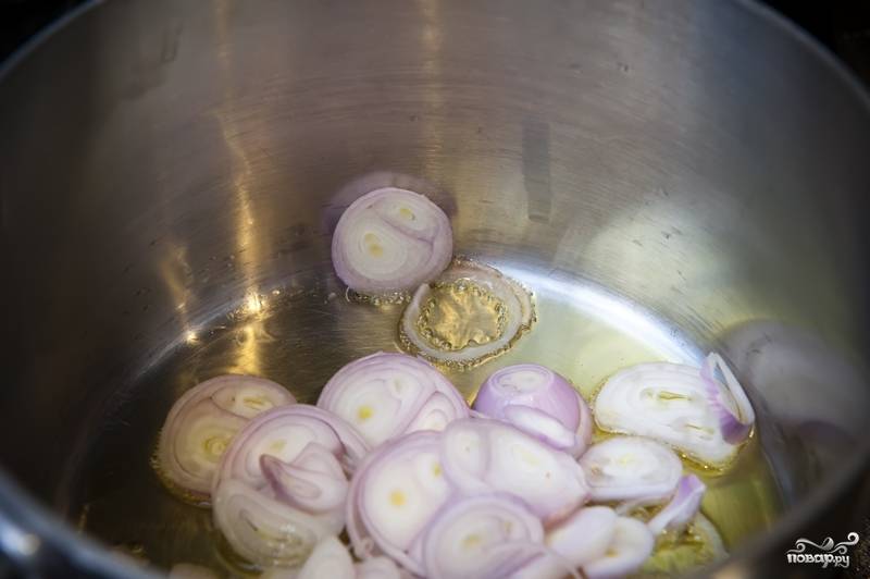 2. В сотейник или кастрюлю (в которой будете варить рис) влейте оливкового масла так, чтобы покрылось дно. Нагрейте и обжарьте нарезанные лук до мягкости.