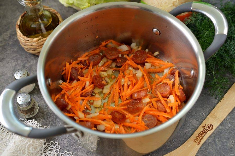 Добавьте в кастрюлю нарезанный лук и натертую морковь. Обжарьте еще около минуты. 
