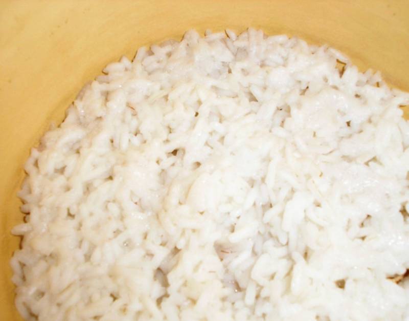 Отварите рис до готовности, форму для запекания смажьте маслом и застелите пергаментом. 