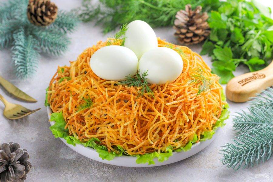 Выложите сверху отварные куриные яйца, украсьте свежей зеленью и подайте приготовленное блюдо к столу. Счастливого вам Нового года!