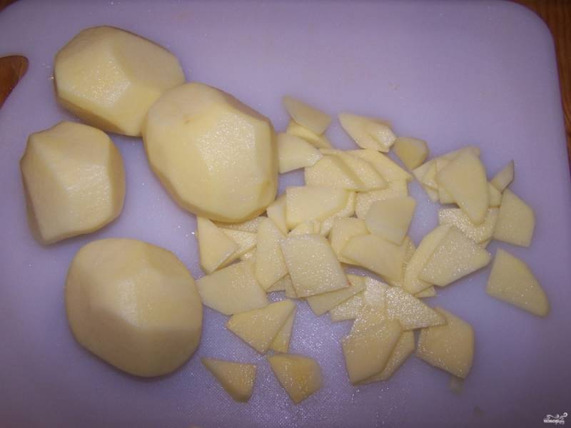 Шаг 3.
Порежьте картофель на мелкие кусочки.  Добавьте в суп. Добавьте поджаренные лук с морковью в кастрюлю.