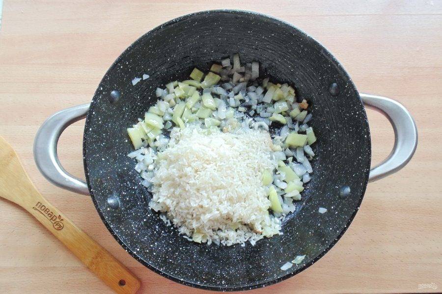 После добавьте рис и жарьте еще 3-4 минуты, перемешивая эти ингредиенты.