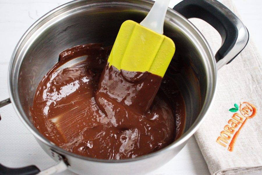 Темный шоколад растопите на водяной бане, добавьте 1 ч. л. растительного рафинированного масла, перемешайте. Добавьте измельченные орехи, перемешайте.
