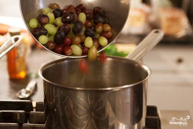 Затем в кастрюлю добавляем виноград. Обязательно разрезаем его пополам. Если виноград большой, то на четвертинки.