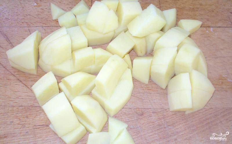 Картофель чистим и нарезаем на небольшие кубики. Наливаем в кастрюлю немного воды и выкладываем в нее нарезанный картофель. 