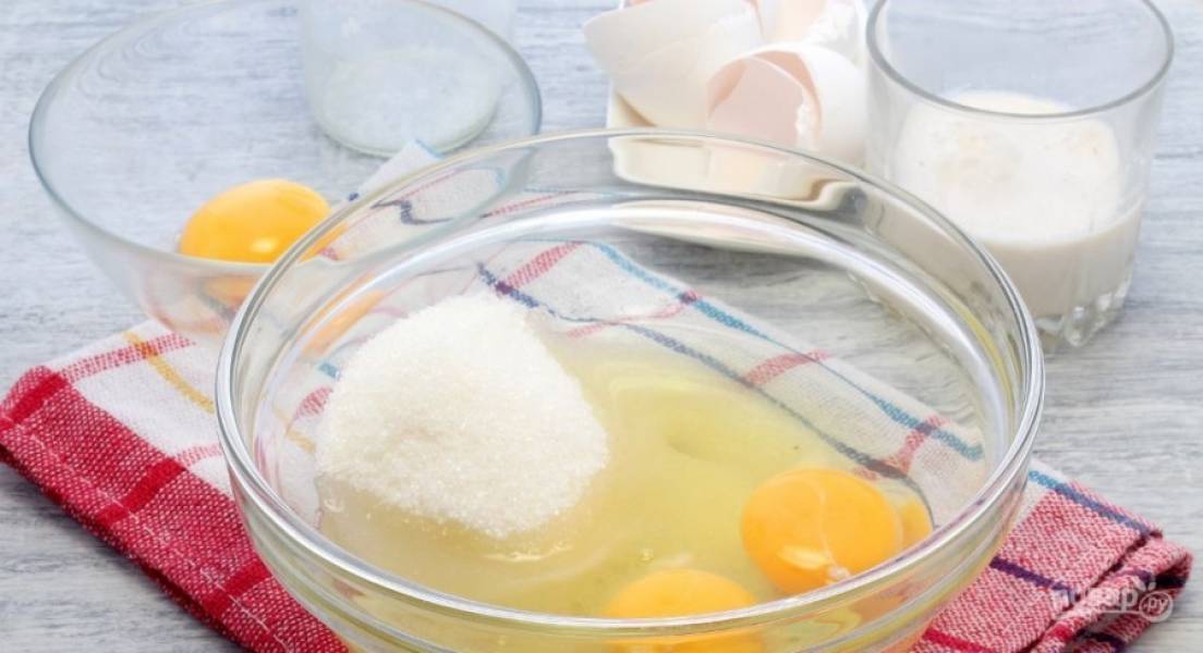 Отделите один желток для смазки. Остальные яйца и белок взбейте со 100 граммами сахара. В другой посуде залейте дрожжи 50 мл тёплого молока и добавьте сахар. Оставьте их набухать на 10 минут.