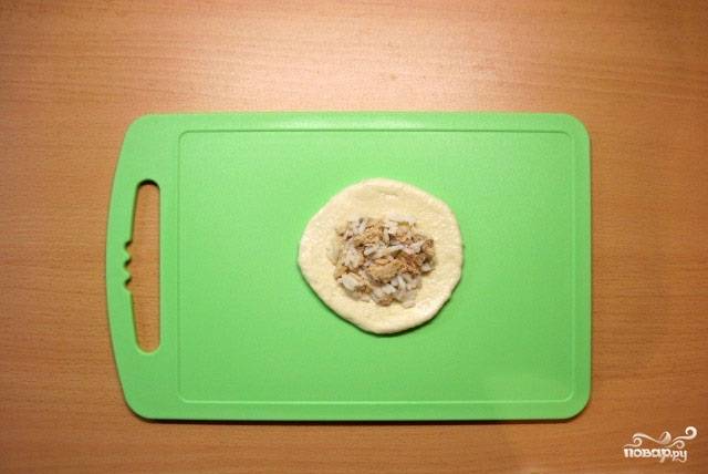 13. Готовое тесто разделяем на кусочки, каждый из которых раскатываем или разминаем, формируя при этом круг. В центр кладем начинку.