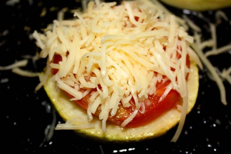 Сверху кладем по одному кружочку помидоры и присыпаем тертым сыром.
