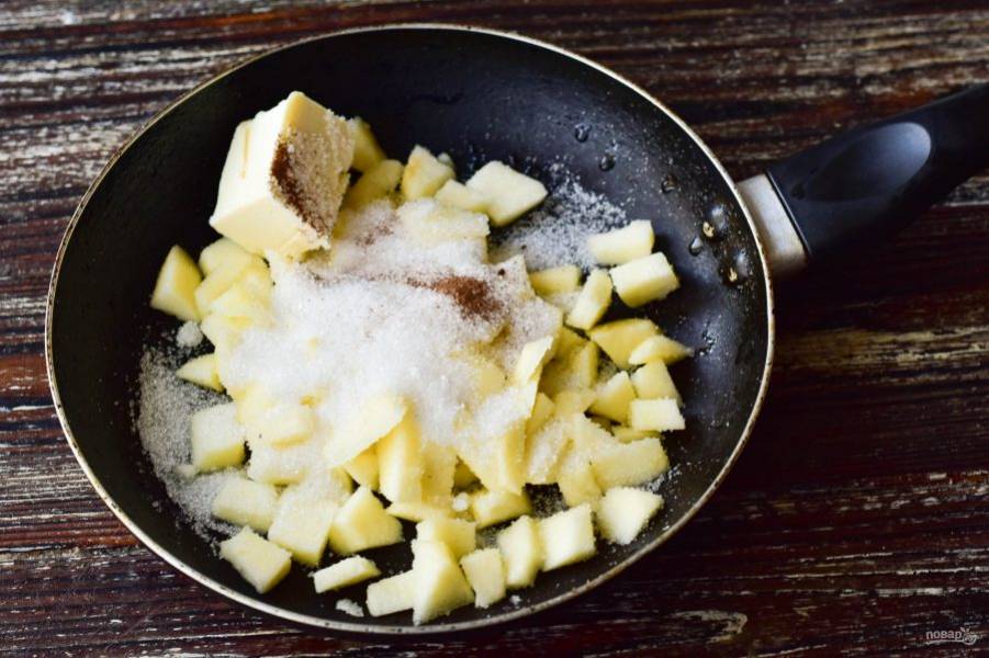 В сковороду выложите сливочное масло, сахар, корицу и мелко нарезанные и предварительно очищенные яблоки.