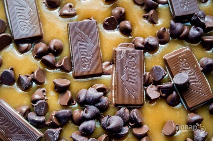 3. Далее посыпьте массу шоколадными каплями. Через 2 минуты распределите шоколад кусочками.