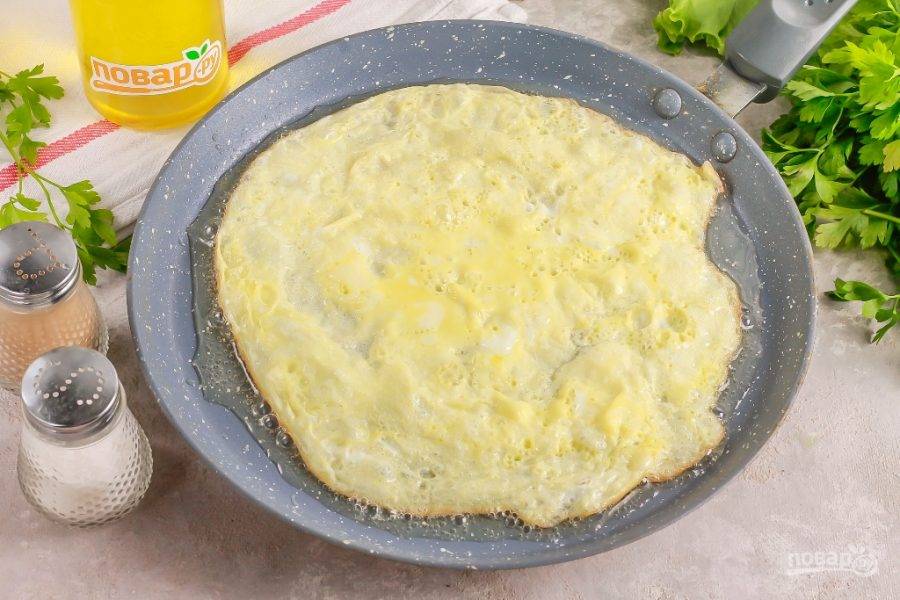 Куриное яйцо взбейте с щепоткой соли в пиале или креманке. Прогрейте в сковороде растительное масло и вылейте в него яичную массу. Обжарьте омлет в течение 2-3 минут и выложите на тарелку для остывания.