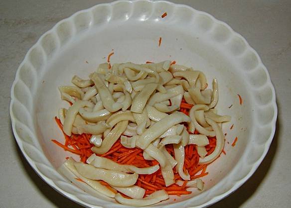 Перекладываем кальмары в тарелку к моркови. Не перемешиваем.