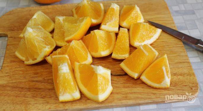 Апельсины вымойте под проточной водой при помощи щетки. Лучше выбирать небольшие плоды с тонкой кожурой. Разрежьте их на крупные куски и достаньте все косточки. 