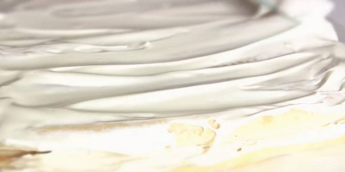 3. Стол застелите пищевой пленкой и выложите на нее палочки из слоеного теста. Смажьте их кремом, выложите второй слой палочек и снова смажьте кремом. Немного крема оставьте, чтобы смазать верх торта.