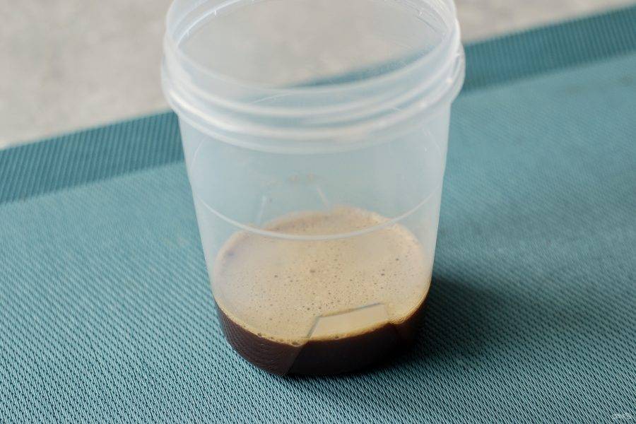 В чистую емкость насыпьте растворимый кофе. Налейте воду комнатной температуры. Перемешайте, чтобы кофе полностью растворилось. 