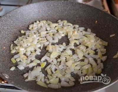 3. На сковороде разогрейте немного растительного масла. Очистите, нарежьте кубиками лук и измельчите чеснок. Обжарьте на среднем огне. 