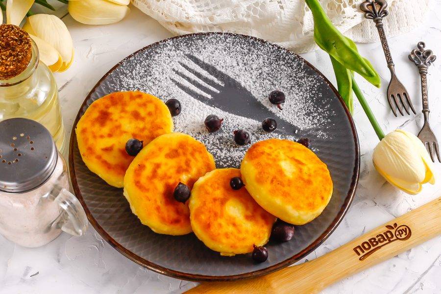 Выложите горячие сырники на тарелку, украсьте по своему вкусу и подайте к столу с горячими напитками.