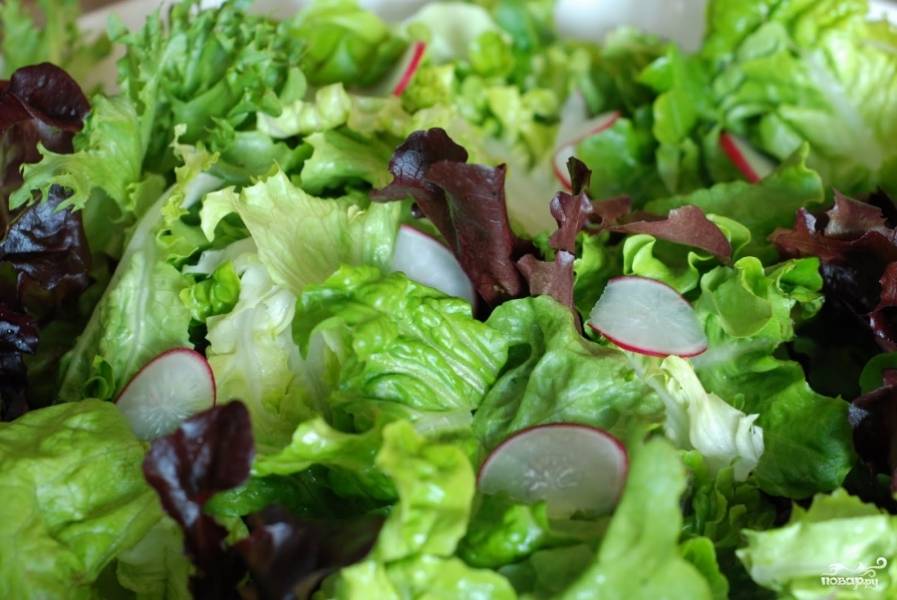 Выкладываем в салатницу листья салата, туда же добавляем немного тонко нарезанной редиски.