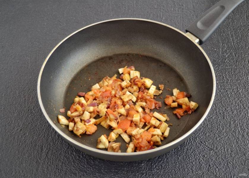 Обжарьте на сковороде измельчённый чеснок и лук до мягкости. Затем добавьте порезанный кубиками помидор и сердцевину баклажана. Добавьте карри, перец и соль, готовьте все вместе 10-15 минут. 