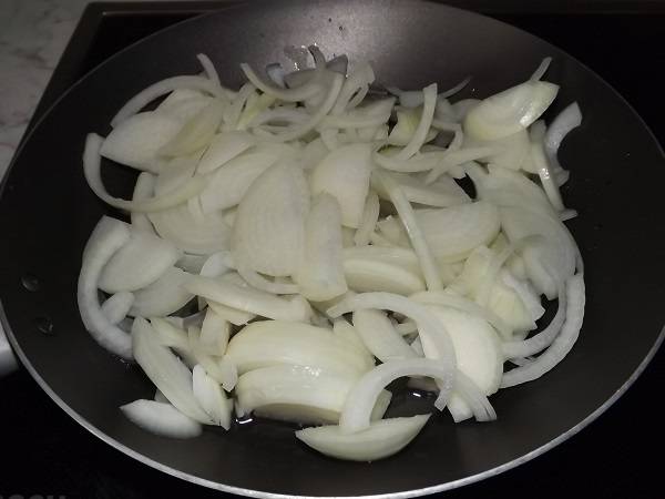 3. А тем временем можно приступить к готовке соуса. Очистить лук и нарезать его тонкими полукольцами. Выложить его на сковороду с небольшим количеством растительного масла и обжарить до прозрачности. 