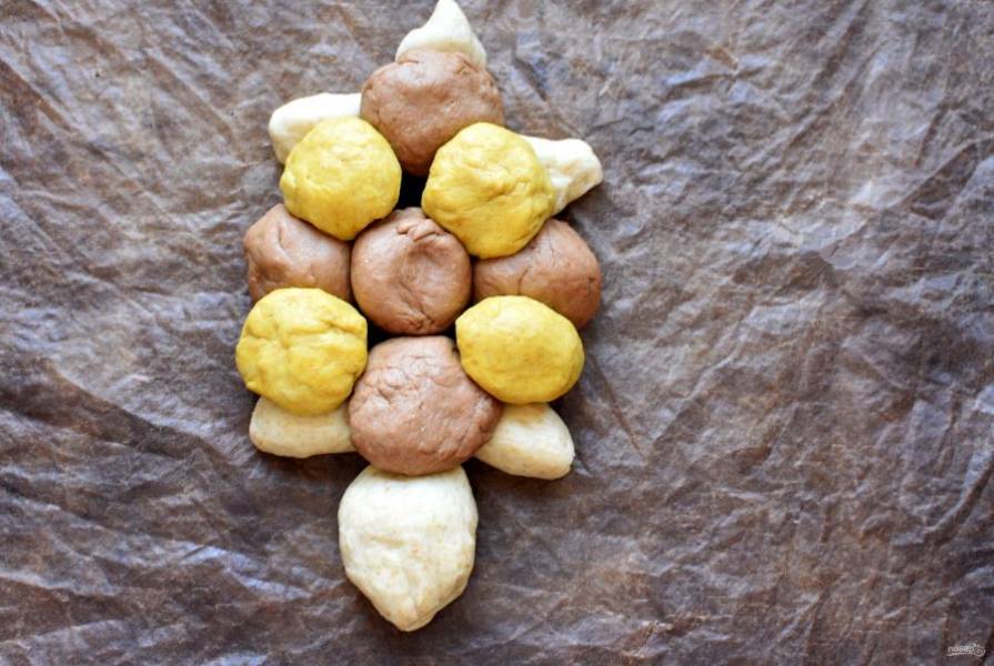Сформируйте некрупные шарики из желтого и коричневого теста. Выложите тесто кругом в два слоя, чередуя по цвету и создавая панцирь черепахи.