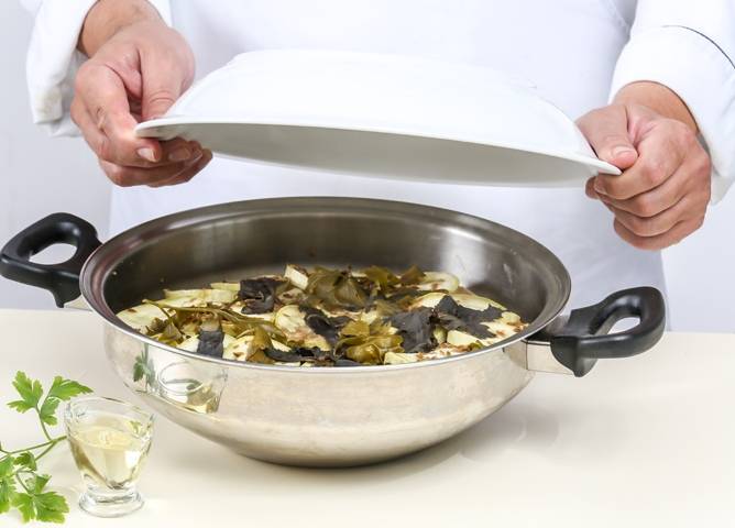 Готовое блюдо аккуратно переверните из кастрюли в большую тарелку. Посыпьте колечками острого перца и свежей зеленью.  Подавайте на стол горячим. 