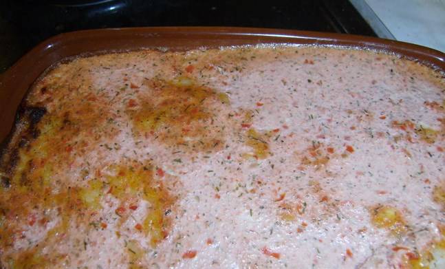 Потом выкладываем рыбу, следом — опять рис, все заливаем сметаной с соусом. Отправляем в духовку на 20 минут при 200 градусах.