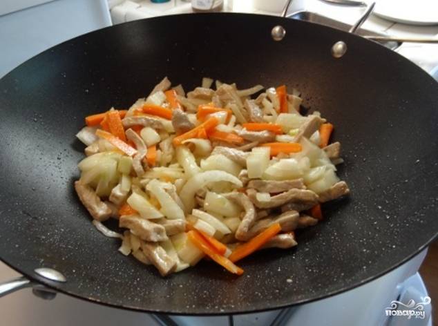 4. Добавьте мелко порезанные овощи в вок и быстро обжаривайте морковь, лук, имбирь, сладкий перец, красный перец.
