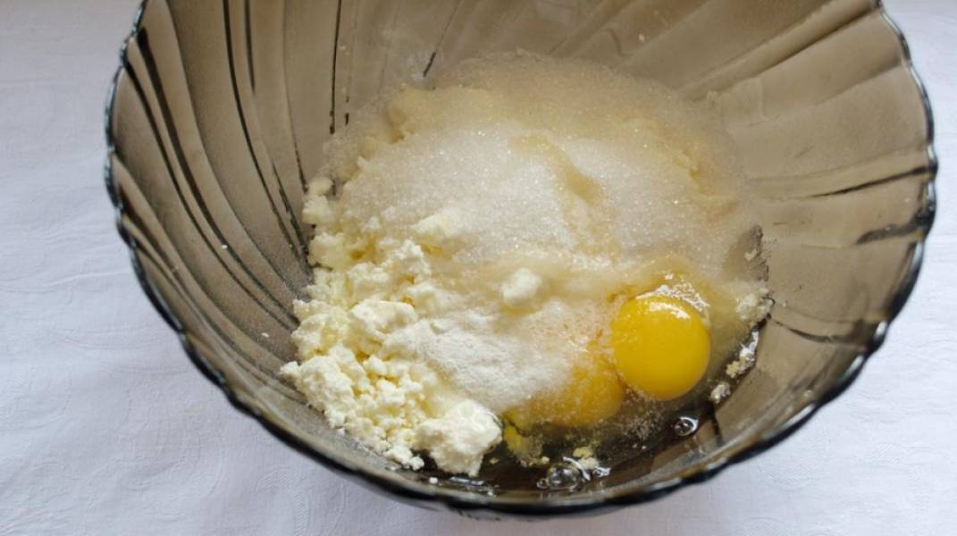 К творогу добавить сахар, яйца, ванилин или ванильный сахар, разрыхлитель. Все смешать венчиком или миксером до однородности. В самую последнюю очередь просейте муку. Замесите тесто. Не удивляйтесь, если оно будет липкое и вязкое - так и должно быть.