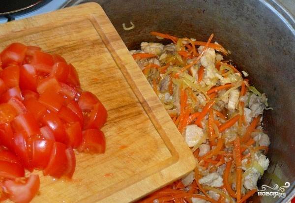 Томаты помойте. Если вы не хотите, чтобы в блюде были шкурки помидоров, то заранее очистите их. Для этого вскипятите воду и опустите в кипяток томаты на несколько минут. Тогда кожица с них слезет очень легко и быстро. Нарежьте помидоры дольками и отправьте в казанок. 