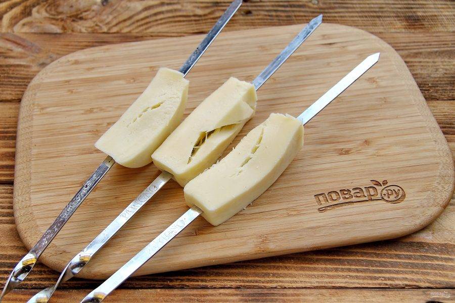 Нанизайте сыр на шампуры. Если сыр не получается разрезать на большие брусочки, то нарежьте его на 2-3 кусочка и затем насадите их  плотно на шампур.