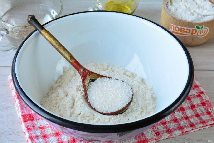 Просейте в миску половину порции муки, всыпьте разрыхлитель и сахар, перемешайте.