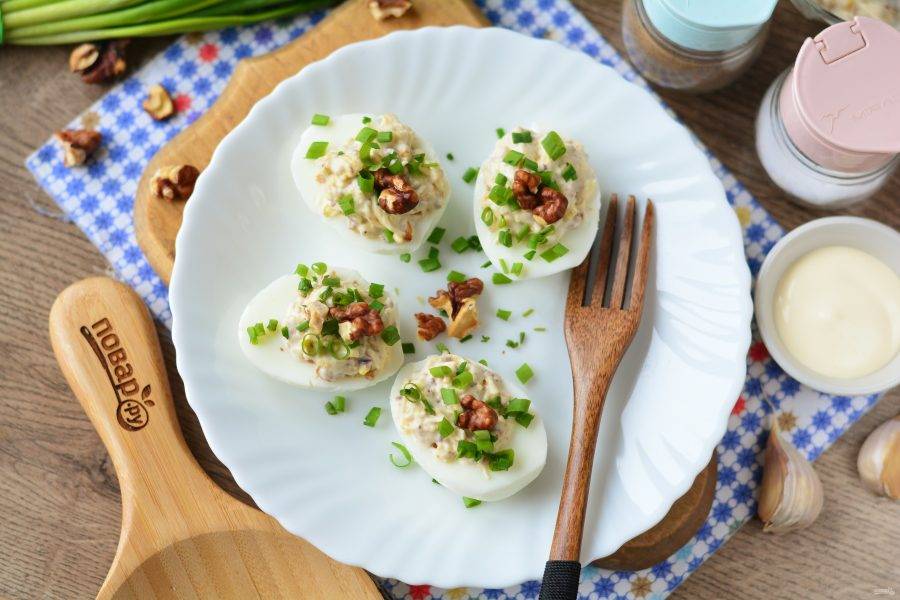 Фаршированные яйца остудите в холодильнике, присыпьте мелко рубленым зеленым луком и подавайте к столу. Приятного аппетита!