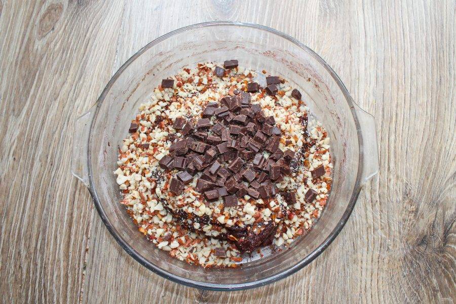 Шоколад крупно порубите и добавьте в миску с тестом и орехами.