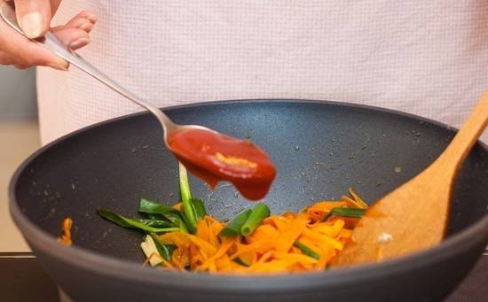 5. На сковороду к овощам добавить томатный соус. Можно добавить соус чили, чтобы скумбрия с морковью и луком в домашних условиях была остренькой. 