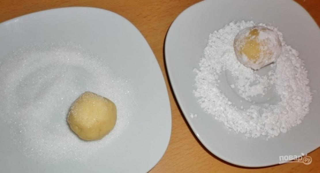 Из теста скатайте небольшие шарики. Обваляйте их в сахаре, а затем — в сахарной пудре.