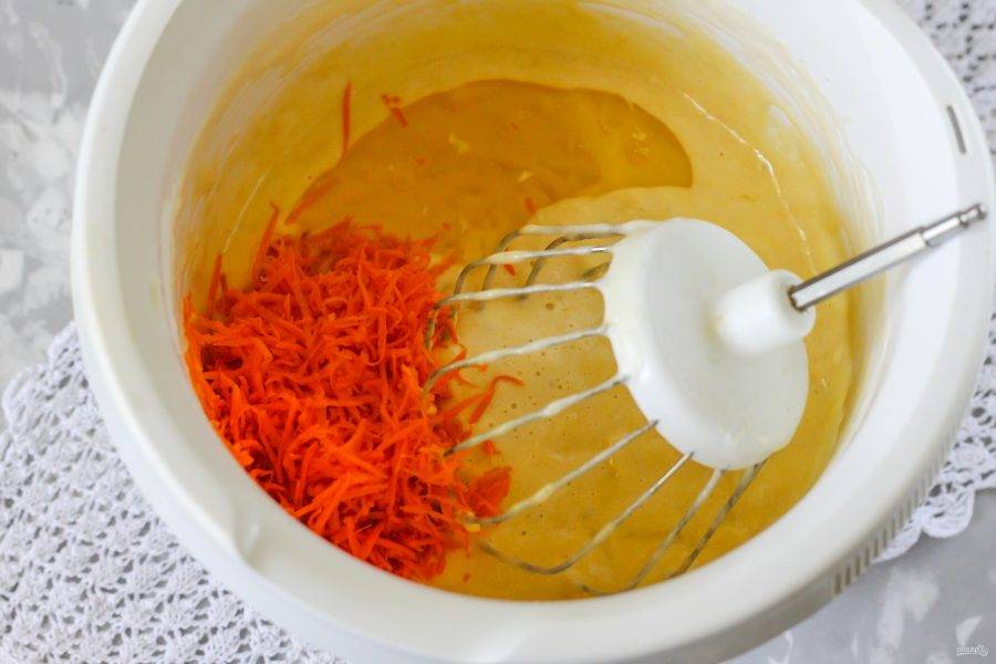 Очистите морковь от кожуры, промойте и натрите половину овоща в емкость, влейте половину растительного масла и аккуратно все перемешайте. На этом же этапе включите духовку на 180 градусов.