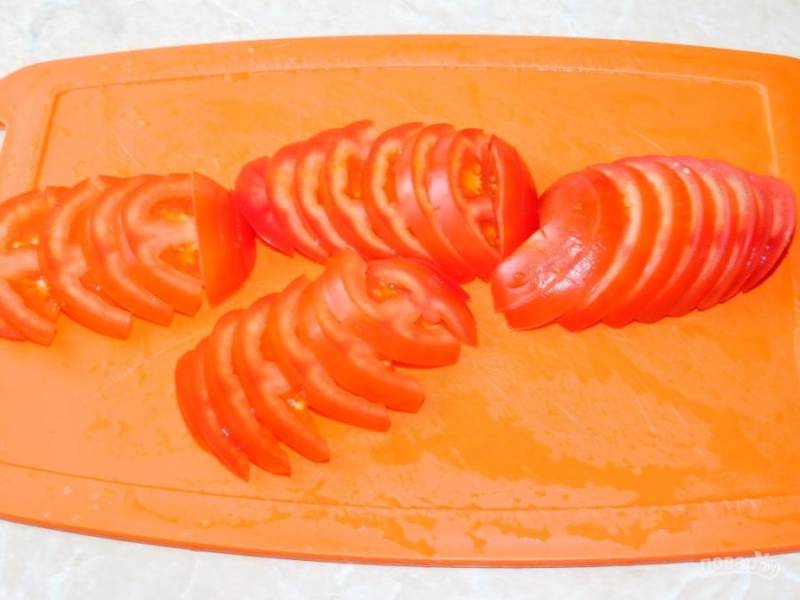 Выложите нарезанные помидоры.