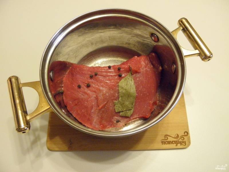 Кусочек говядины без прожилок (у меня задняя часть) положите в кастрюлю, добавьте соль, перец и лавровый лист. Залейте кипятком и доведите до кипения. Варите 1,5 часа до мягкости мяса.