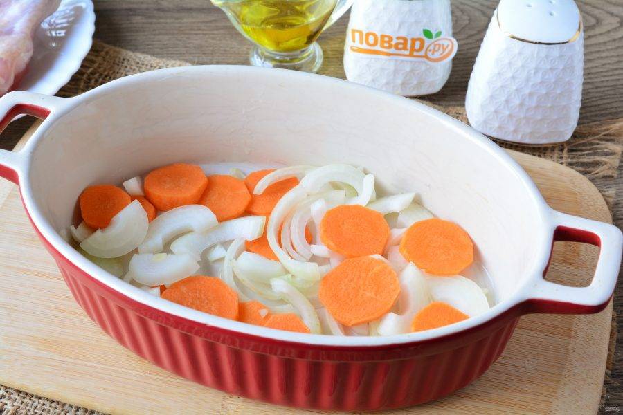Форму для запекания смажьте маслом, выложите ровным слоем лук и морковь.