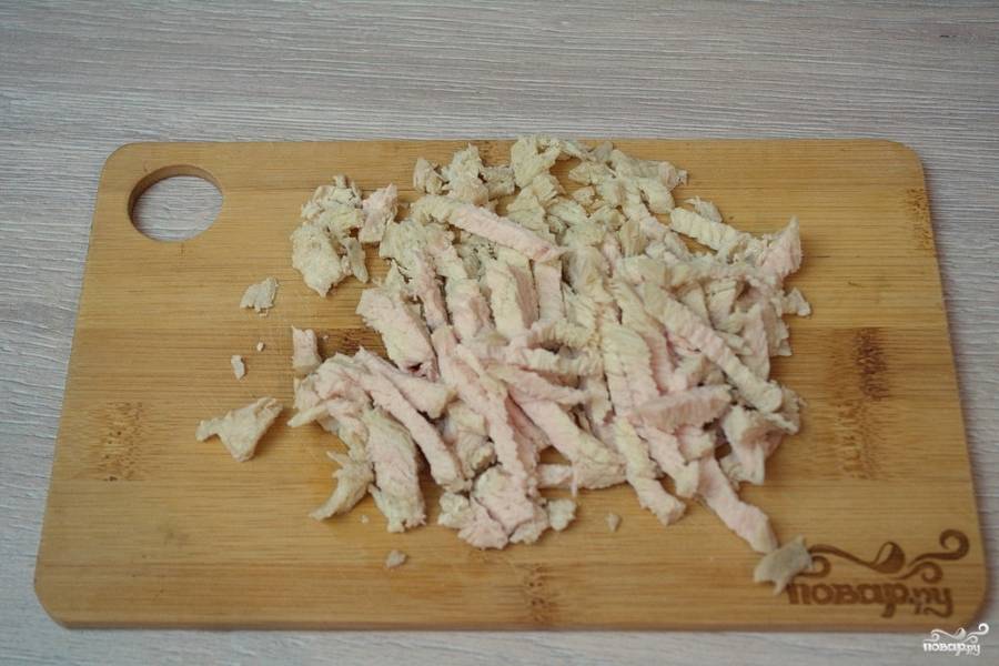 Отварное мясо курицы нарезаем небольшой соломкой. Для приготовления мяса лучше взять куриное филе. Оно более постное. При варке мяса в бульон можно положить коренья, что придаст мясу больше вкуса и аромата.