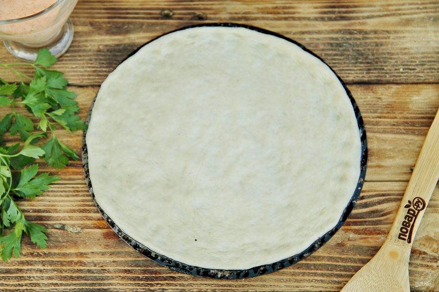 У меня домашнее дрожжевое тесто, специально приготовленное для пиццы, раскатываем его в форме круга или растягиваем руками и выкладываем на смазанную маслом форму, подходящую для приготовления на мангале.